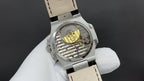 Patek Philippe watch, open caseback showing movement, steel and black leather strap