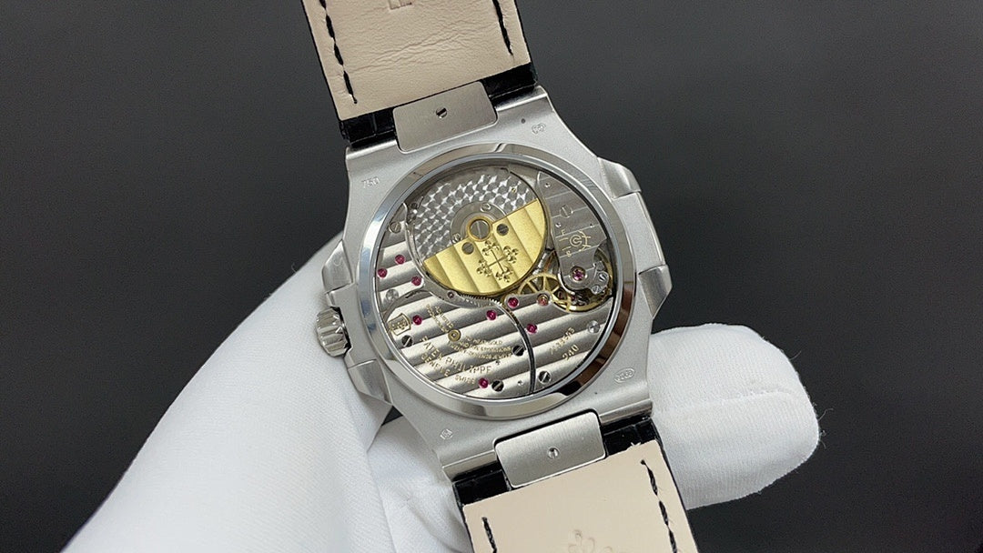 Patek Philippe watch, open caseback showing movement, steel and black leather strap