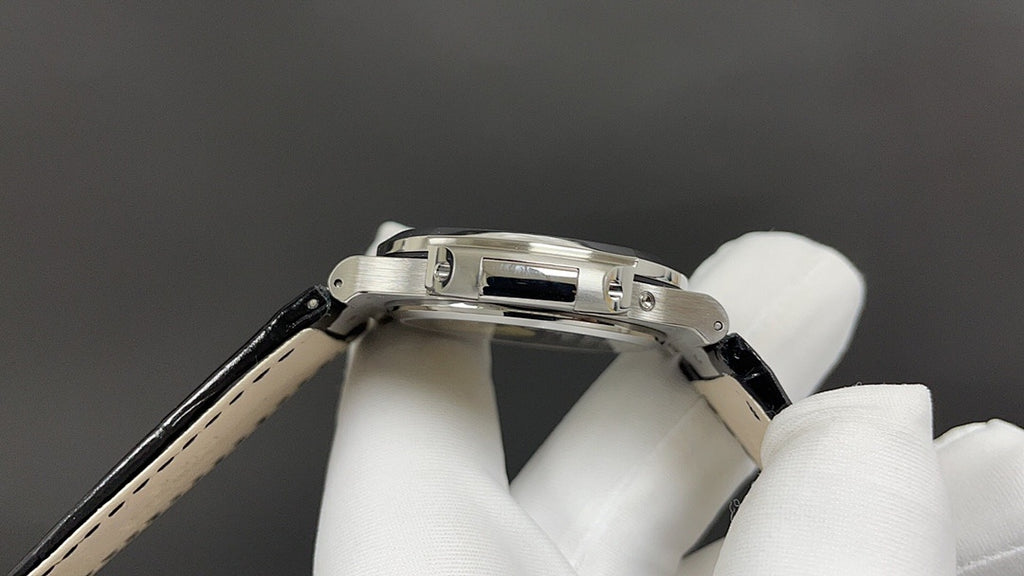 Patek Philippe watch, side view of steel case and black leather strap with stitching