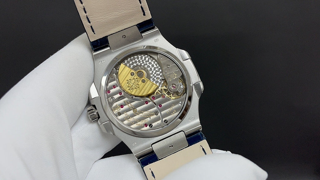 Patek Philippe watch back view, visible mechanical movement, blue leather strap.