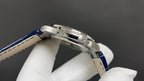 Patek Philippe watch side view, stainless steel case with blue leather strap.