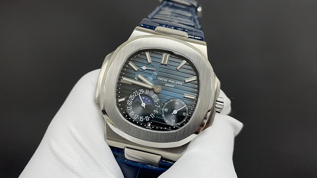 Patek Philippe watch front view, black dial with blue accents, blue leather strap.