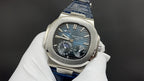 Patek Philippe watch front view, black dial with blue accents, blue leather strap.
