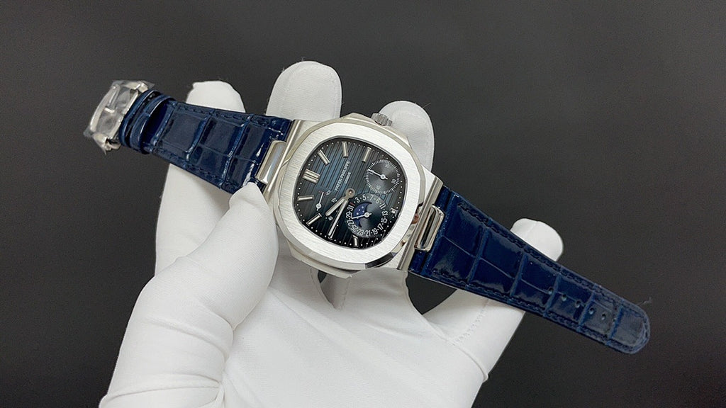Patek Philippe watch, blue leather strap and dark blue-black dial on wrist.