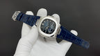 Patek Philippe watch, blue leather strap and dark blue-black dial on wrist.