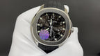 Patek Philippe wristwatch with black dial, purple motif, and black rubber strap