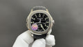 Patek Philippe watch with black dial, gold-tone bezel, and black strap