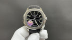 Patek Philippe watch with black dial, gold-tone bezel, and black strap