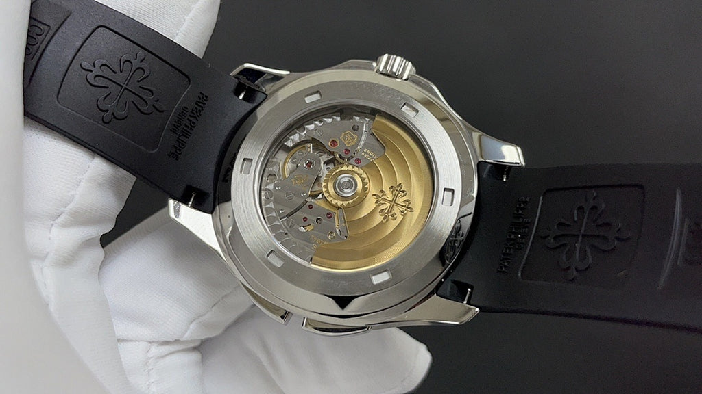 Patek Philippe watch caseback showing automatic movement, black strap