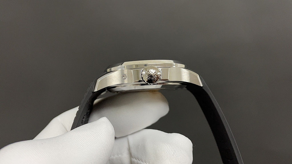 Patek Philippe watch crown on silver case, black strap edge