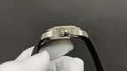 Patek Philippe watch crown on silver case, black strap edge