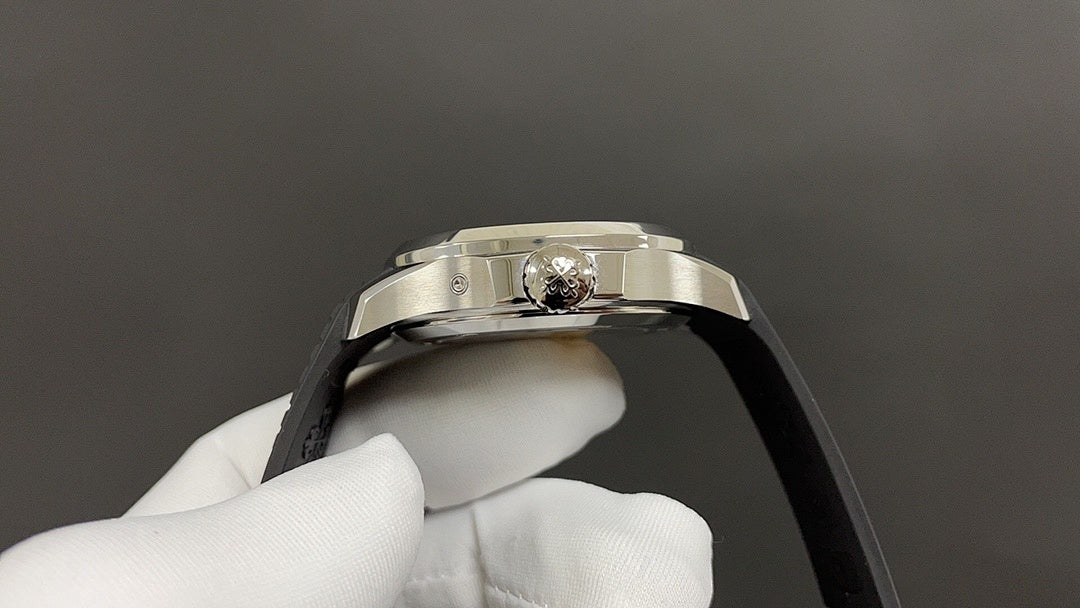 Patek Philippe watch crown on silver case, black strap edge