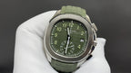 Round wristwatch with green dial and green rubber strap, silver-tone case on white gloves
