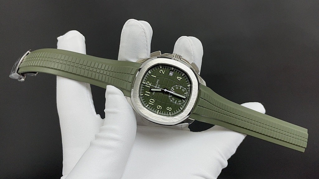 Green wristwatch on white gloves with green rubber strap extended and silver-tone case
