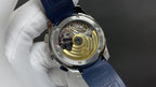 Patek Philippe watch case back with visible movement on blue strap