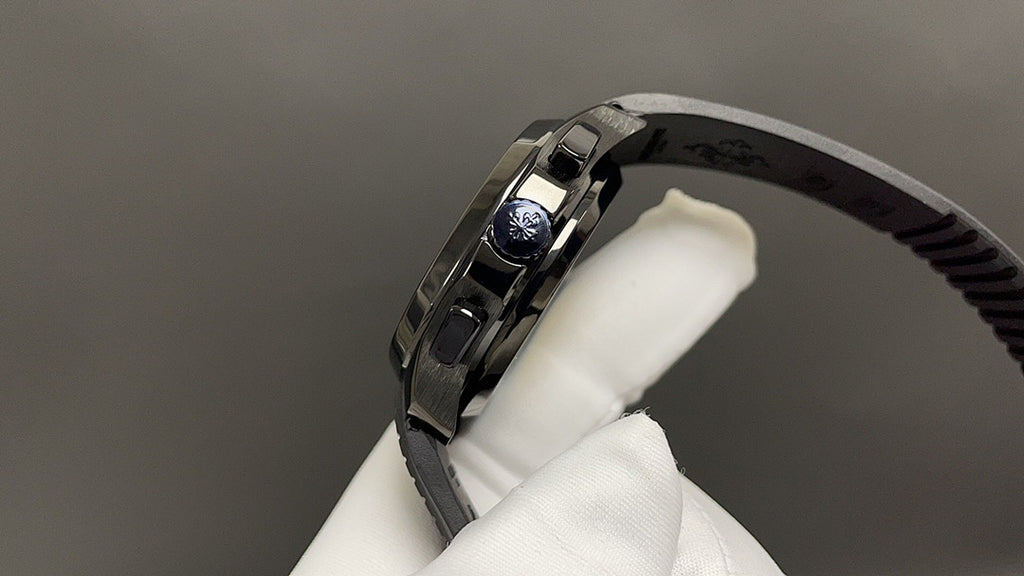 Patek Philippe watch crown side with brushed metal case and black rubber strap