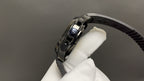 Patek Philippe watch crown side with brushed metal case and black rubber strap