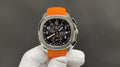 Patek Philippe wristwatch with orange rubber strap and black dial, stainless steel bezel.