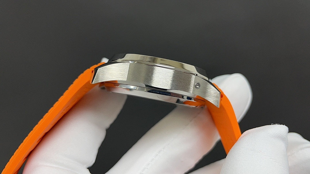Patek Philippe wristwatch side close-up with orange strap and polished stainless case.
