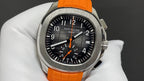 Patek Philippe wristwatch with orange rubber strap and black dial, chronograph subdials.