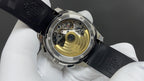 Patek Philippe watch with exposed movement back, gold-toned parts, black rubber strap