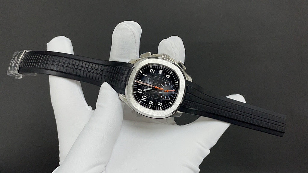 Patek Philippe watch on black strap with black dial, orange hands, steel case