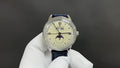 Patek Philippe wristwatch with white dial, blue leather strap, Roman numerals.