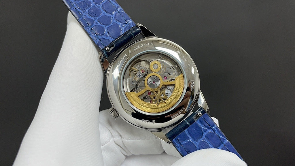 Patek Philippe wristwatch case with visible mechanical movement, blue leather strap.