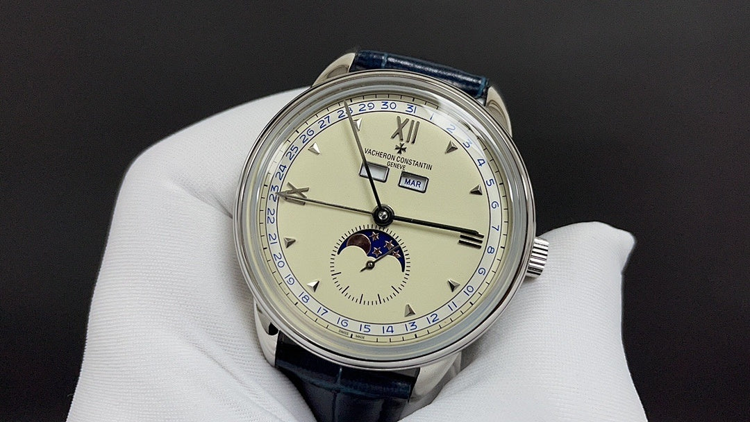 Patek Philippe wristwatch with cream dial, blue leather strap, subdials and Roman numerals.