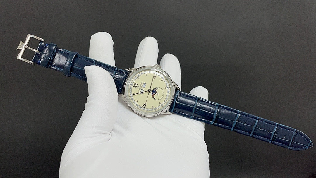 Patek Philippe wristwatch on glove, blue leather strap with buckle, cream dial.