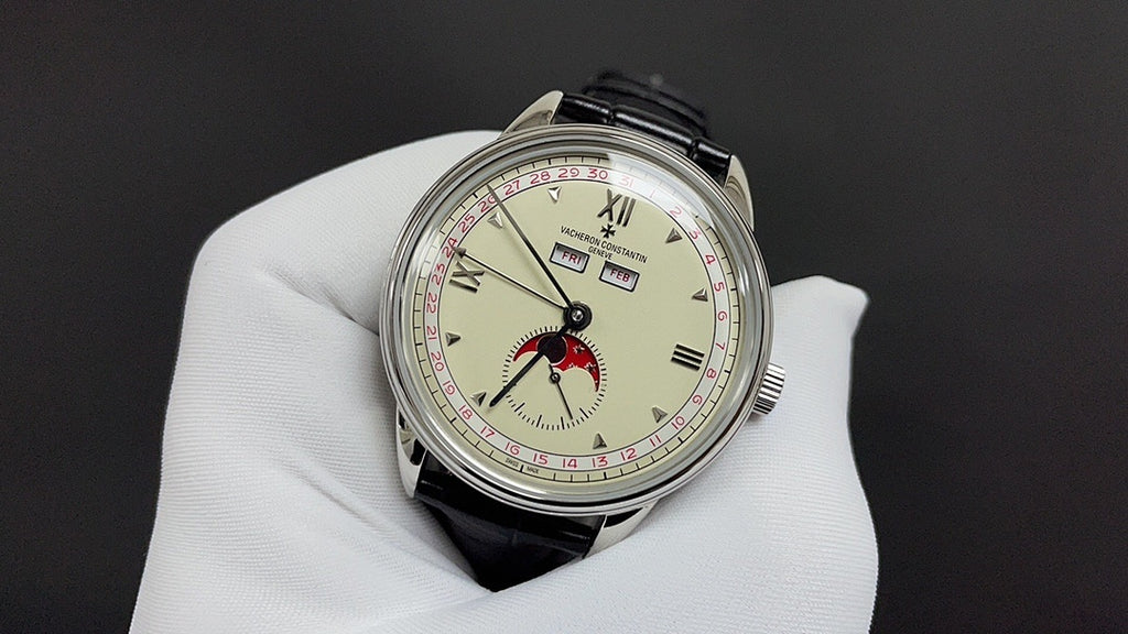 Stainless steel wristwatch with cream dial, red bird motif, and black leather strap