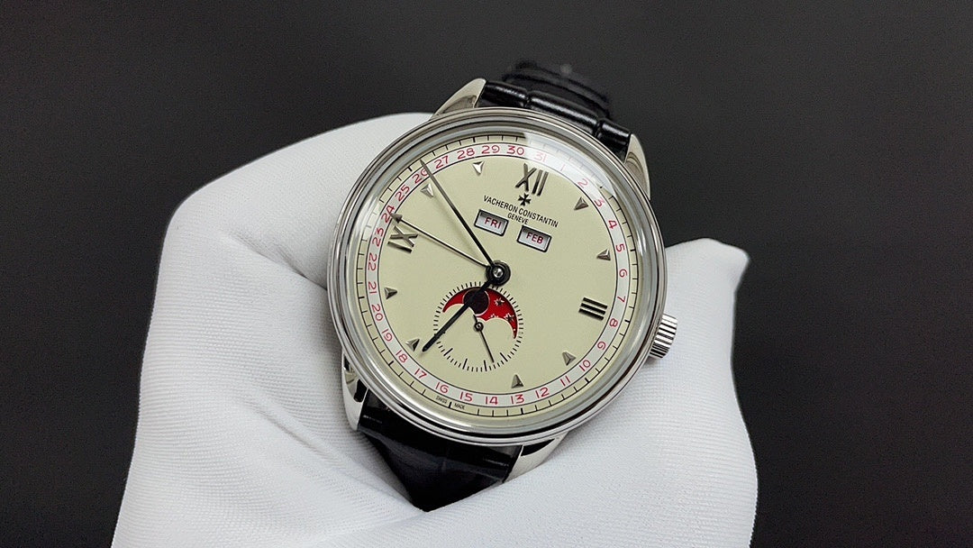 Stainless steel wristwatch with cream dial, red bird motif, and black leather strap