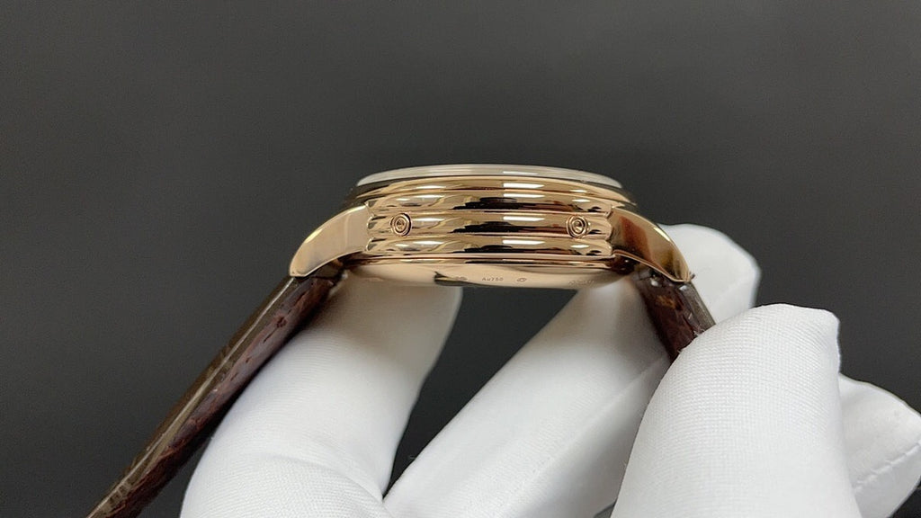 Luxury wristwatch case back, gold-tone finish with brown leather strap
