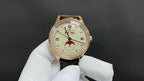 Luxury wristwatch with gold-tone case, white dial, brown leather strap