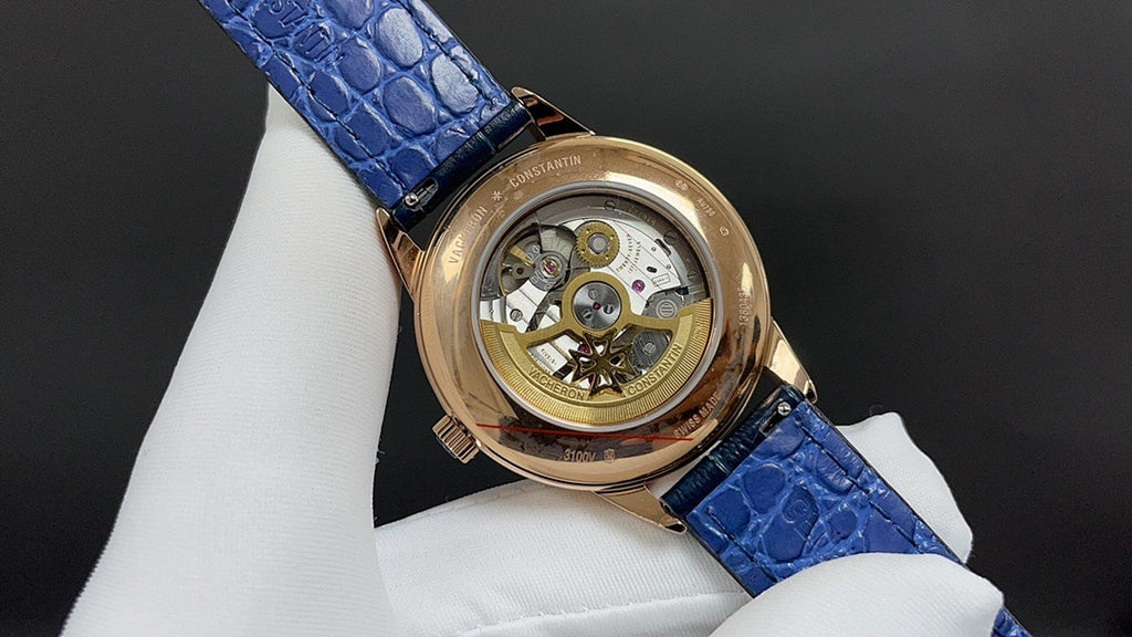 Patek Philippe watch with blue leather strap and gold-tone case, open view of movement.