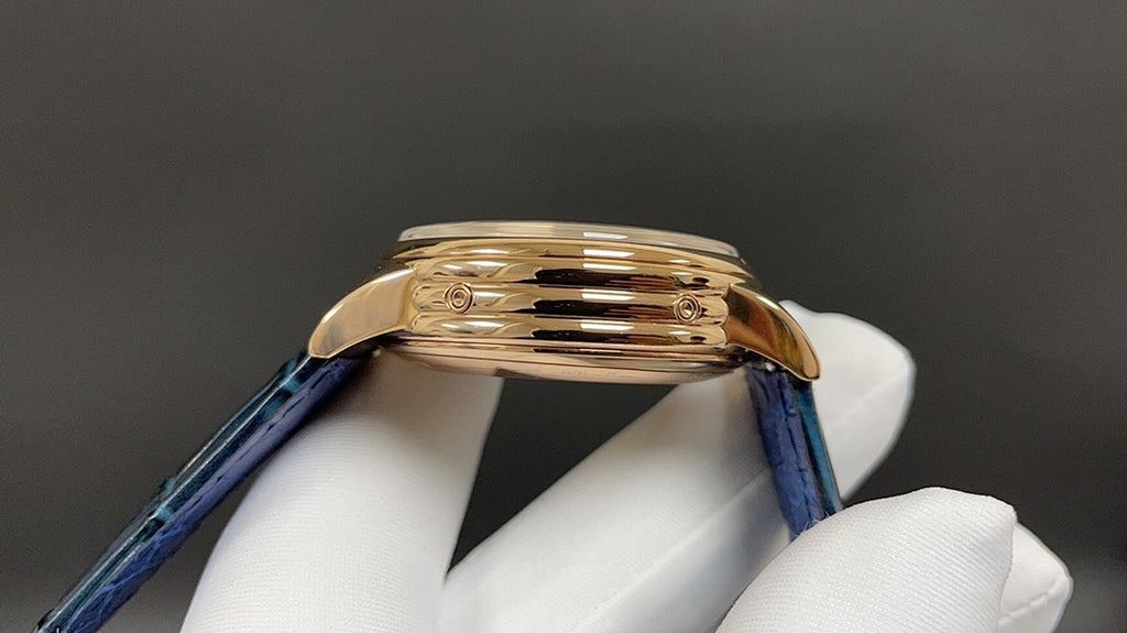 Patek Philippe watch with blue leather strap and gold-tone case, side profile.
