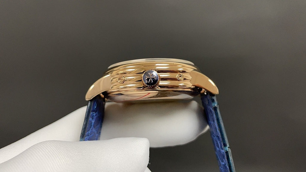 Patek Philippe watch with blue leather strap and gold-tone case, crown side detail.