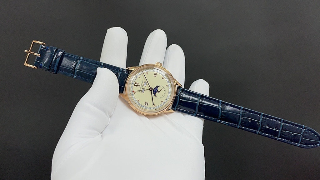Patek Philippe watch with blue leather strap and gold-tone case held on white gloves.