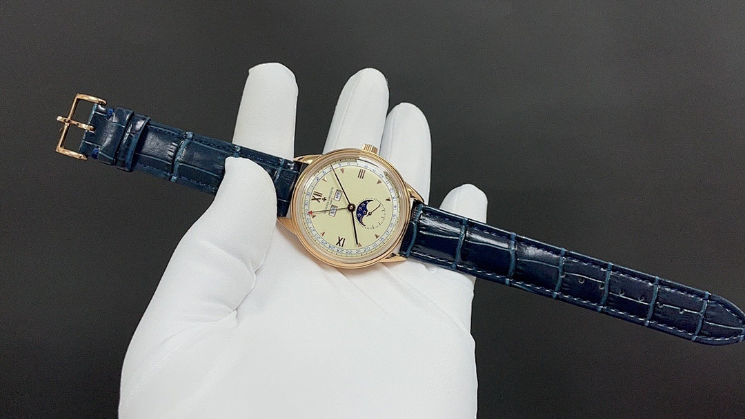 Patek Philippe watch with blue leather strap and gold-tone case held on white gloves.