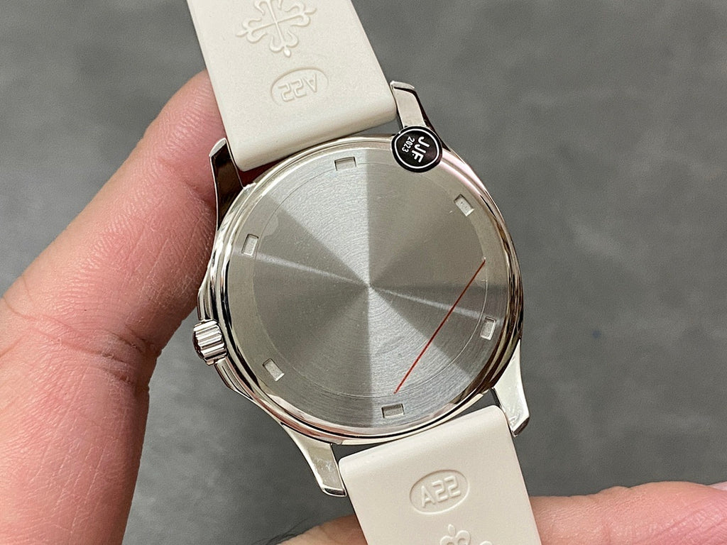 Round watch caseback with faceted finish and textured white rubber strap