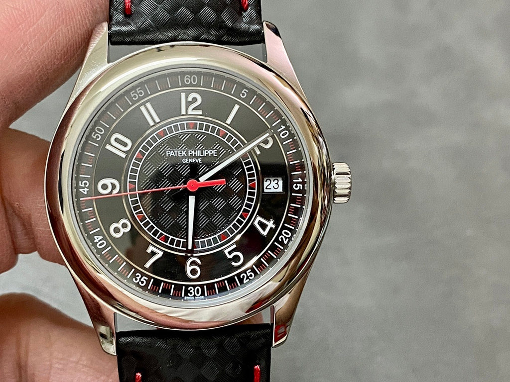 Round stainless watch with dark dial, red hands, and black patterned leather strap
