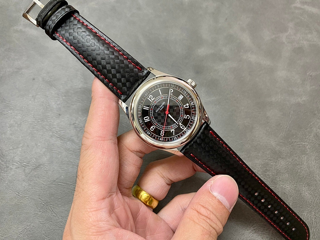 Small round watch with dark dial, red accents, and black leather strap