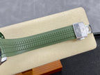 Green rubber watch strap with silver buckle clasp on display stand