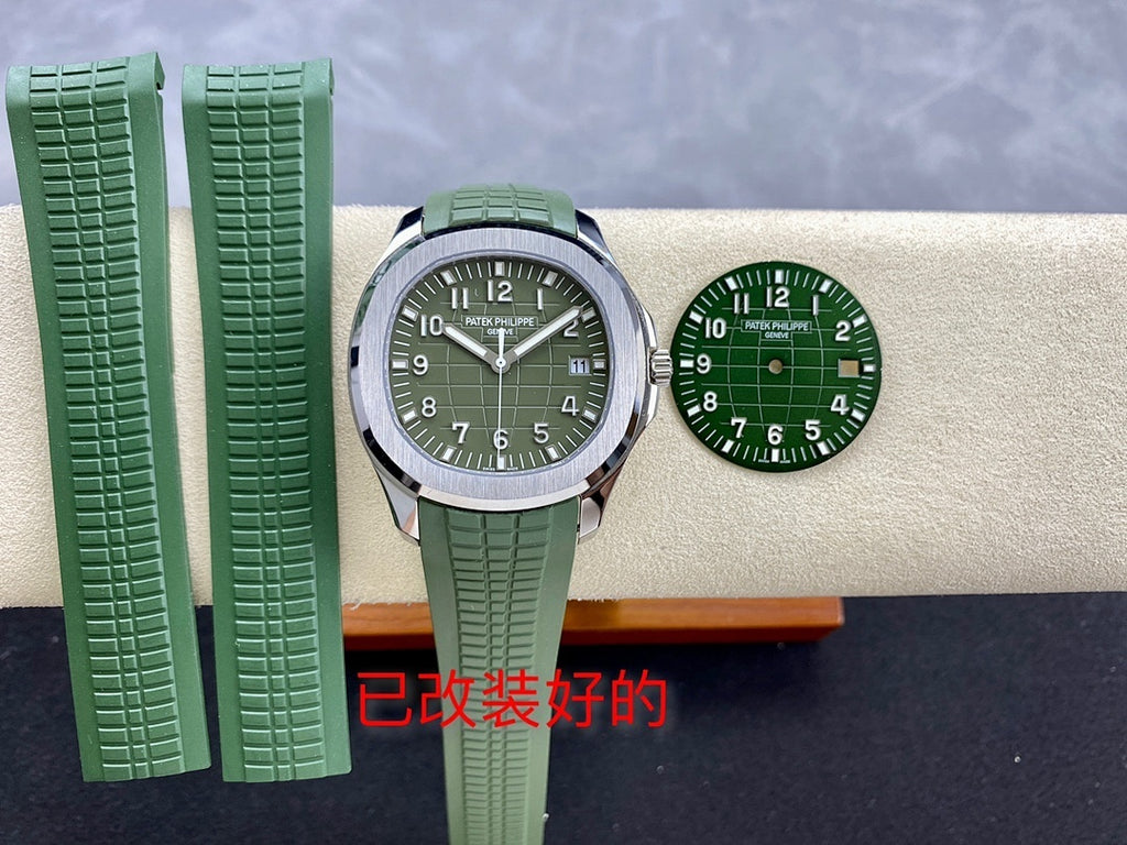 Green dial wristwatch with green rubber strap and silver case with extra straps
