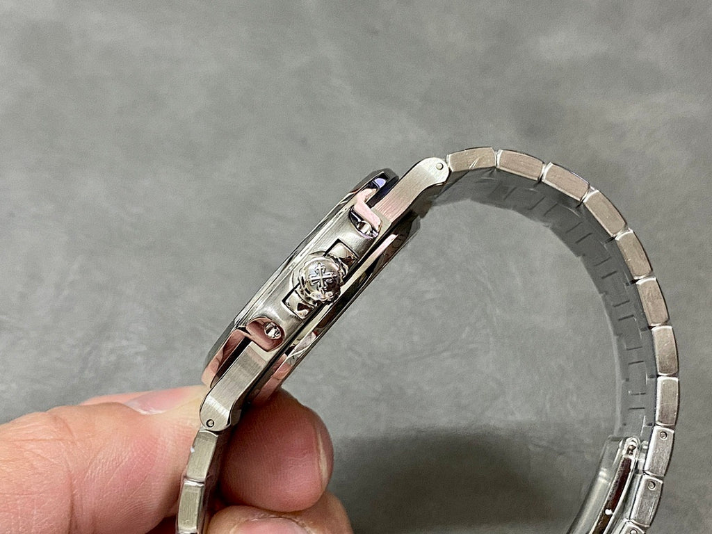 Patek Philippe watch with silver bracelet, crown side detail, and polished case