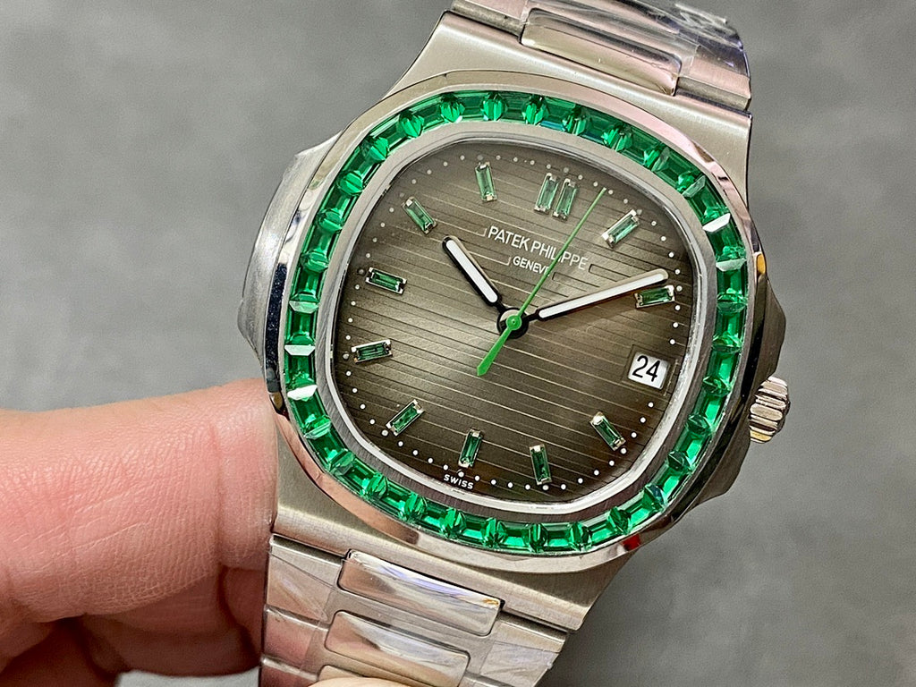 Patek Philippe watch with green bezel, silver bracelet, gray dial, and date window at 24
