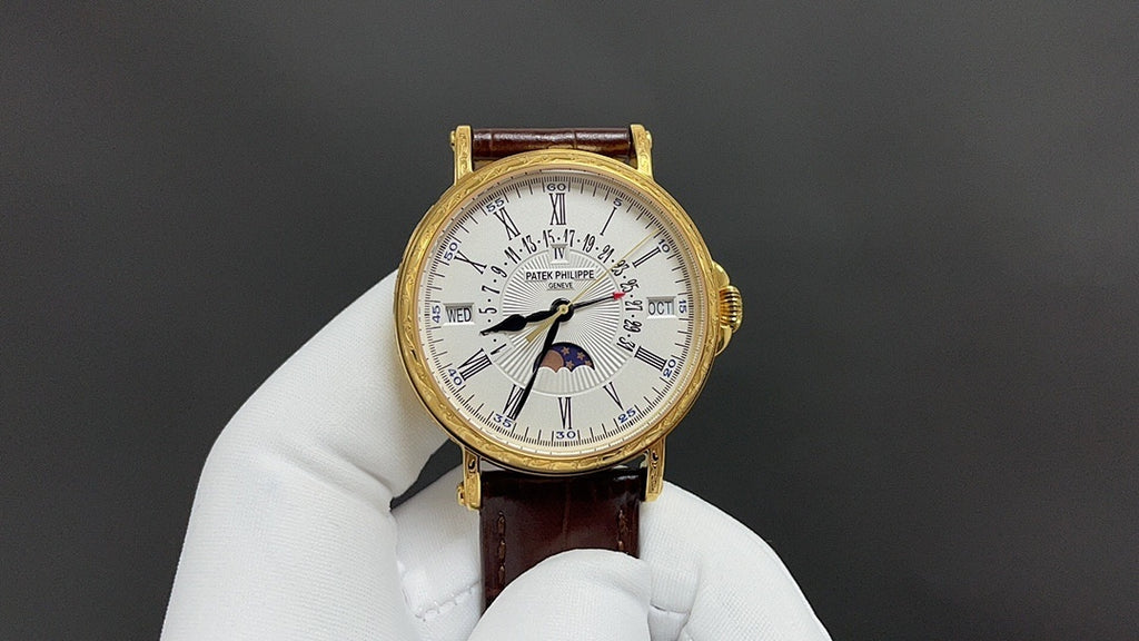 Patek Philippe watch with white dial, gold-tone case, brown leather strap.