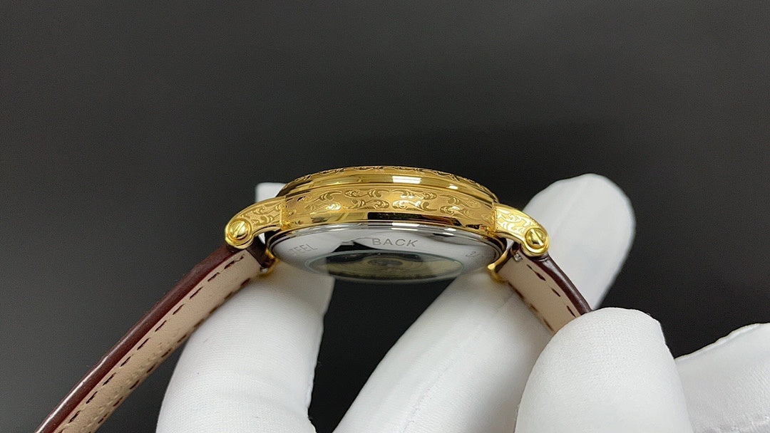 Patek Philippe watch case back with gold-tone finish and brown leather strap.