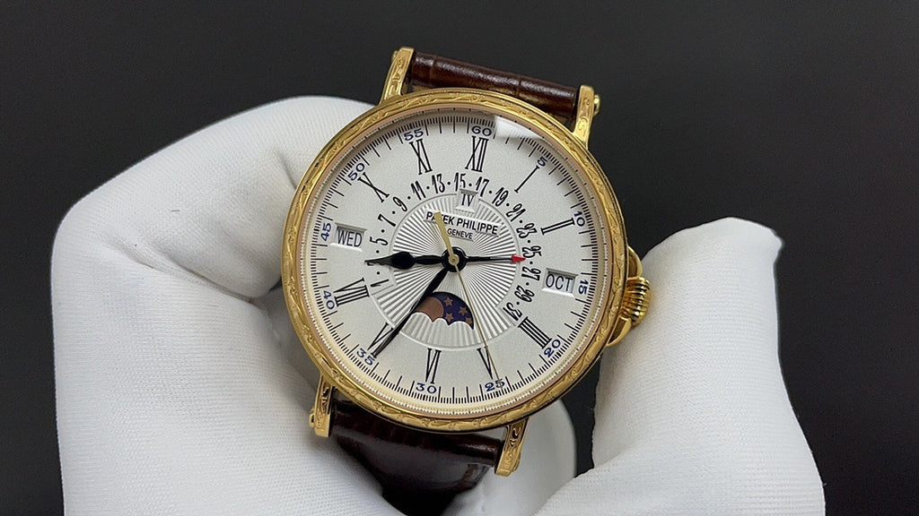 Patek Philippe watch with white dial, black Roman numerals, brown leather strap.