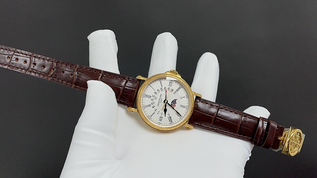 Patek Philippe watch on brown leather strap with gold-tone bezel, white dial.
